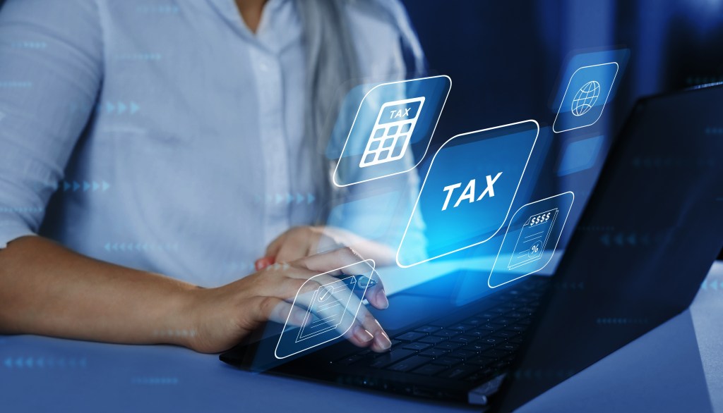 Hands on a laptop with tax icons