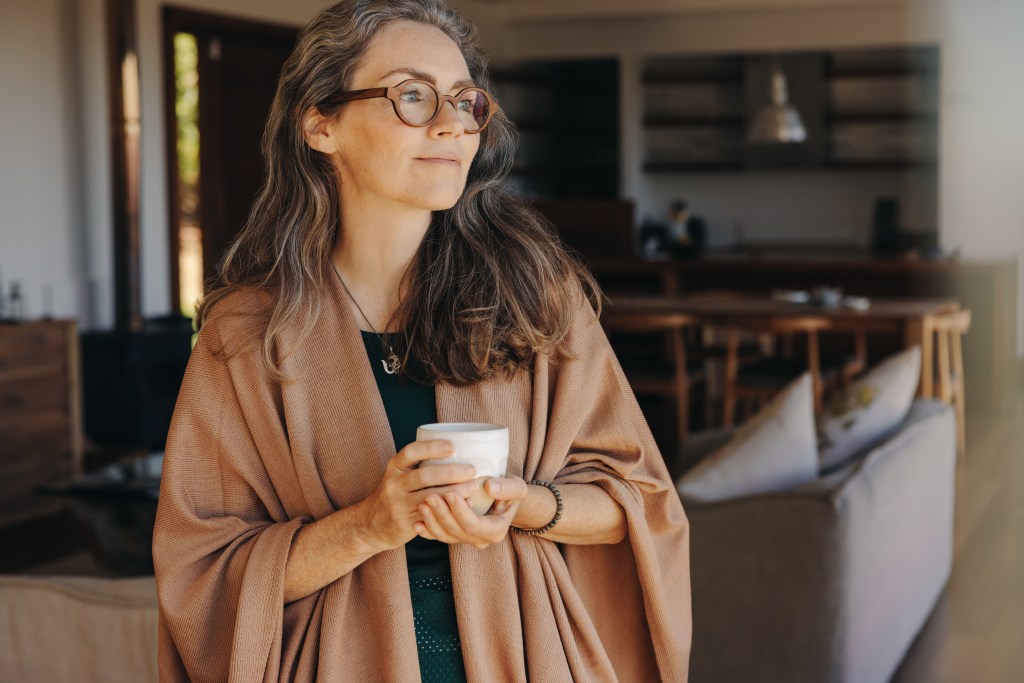 Woman with a coffee looking out a window